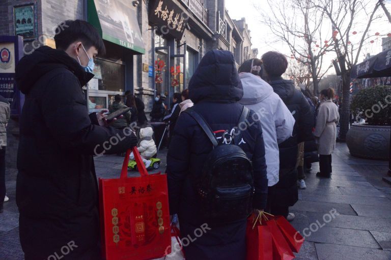 前门大街冬季场景，老字号吴裕泰门前排队买绿茶冰激凌的人群