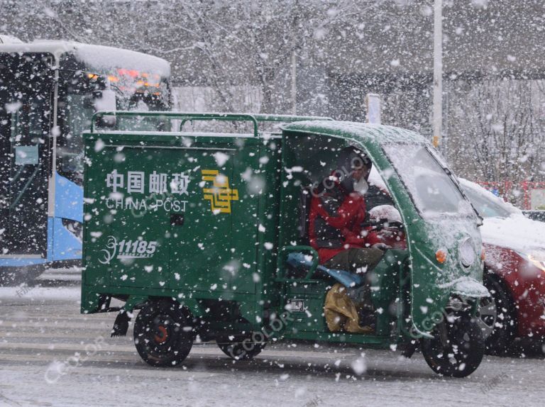 场景类：新冠防控期间，中国邮政车辆在雨雪中运送快递